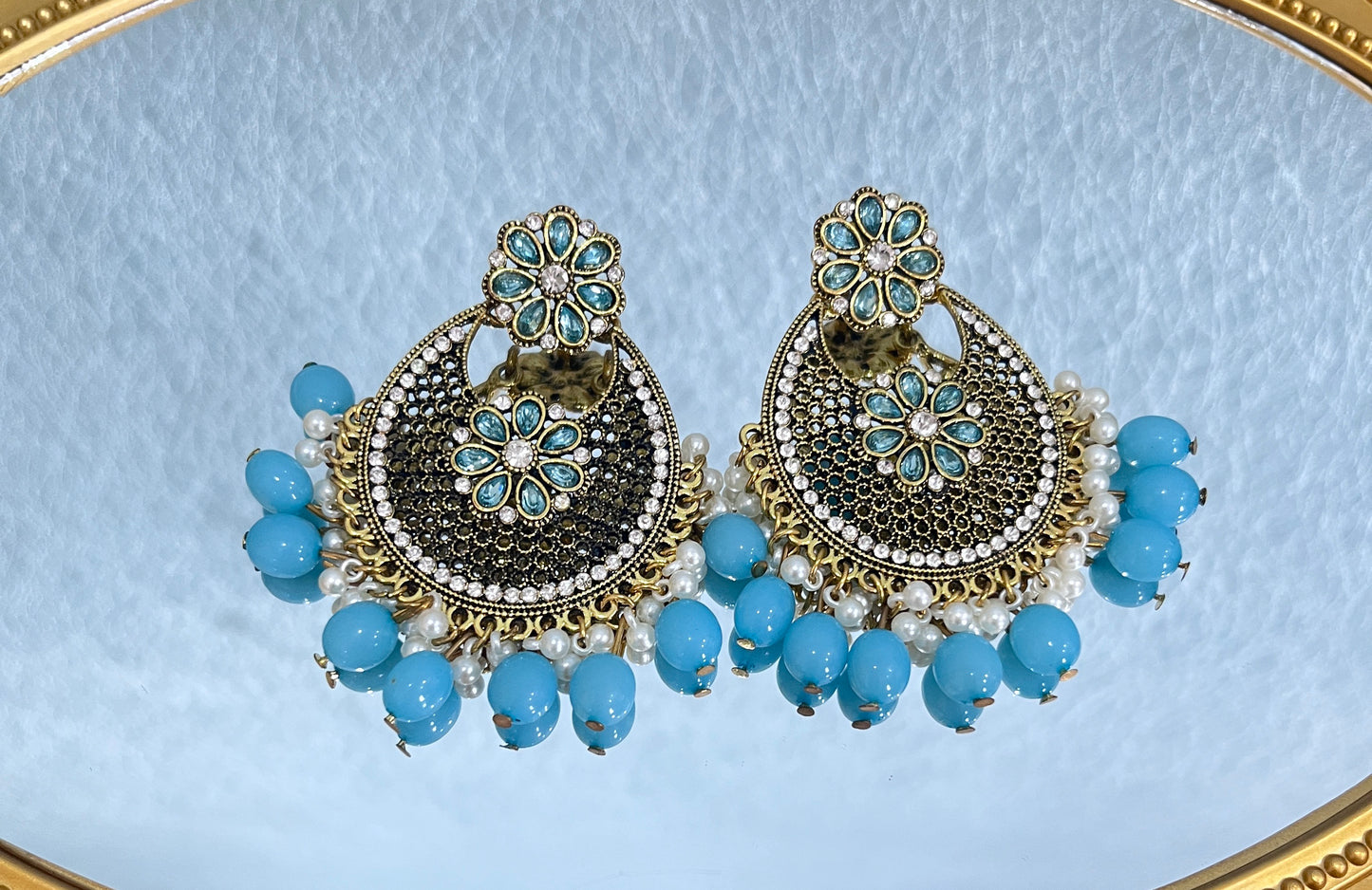 Con una compra de $100 o más en nuestra tienda, podrás recibir un par de aretes vintage de circonitas y diamantes de imitación de estilo bohemio.